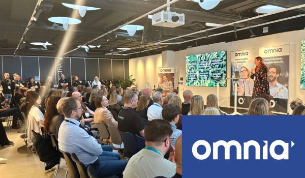 Omnia intranet presentation for a large audience in a professional conference space.